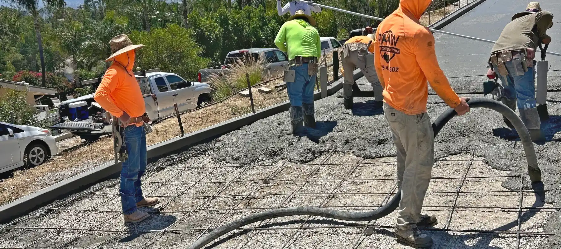 Raaw Concrete Inc. crew pumping and placing concrete over a rebar grid on a hillside driveway in Southern California