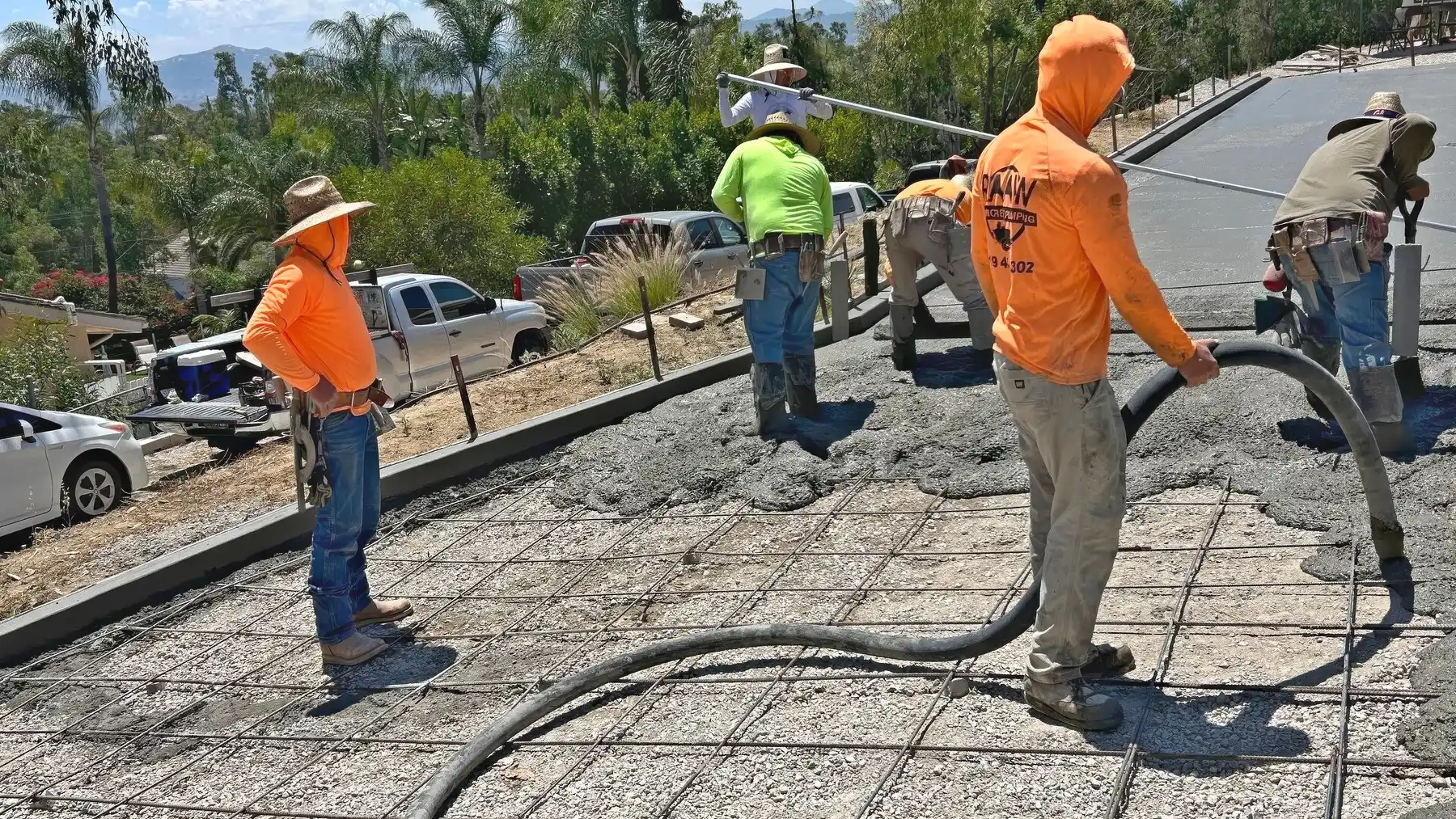 Raaw Concrete Inc. crew pumping and placing concrete over a rebar grid on a hillside driveway in Southern California