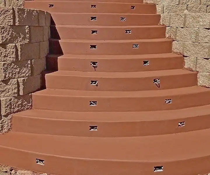Curved terracotta-colored concrete stairway between split-face block retaining walls