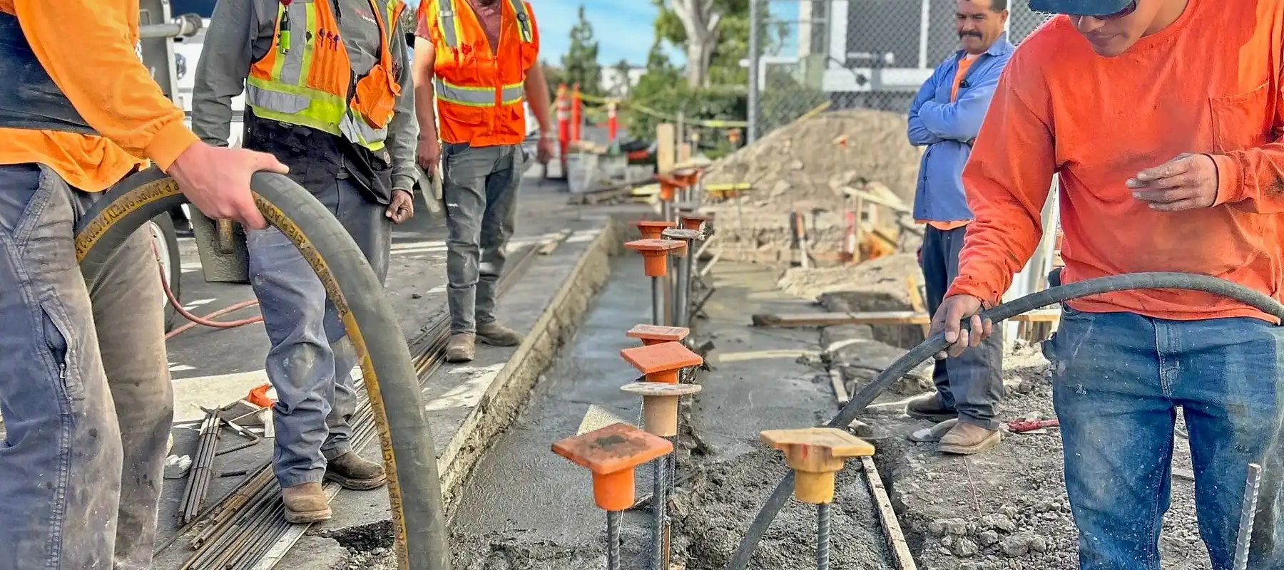 Raaw Concrete Inc. crew pumping concrete into a rebar-reinforced footing trench